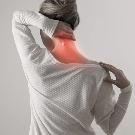 Person viewed from behind holding the neck, with a red highlighted area on the upper back and neck.